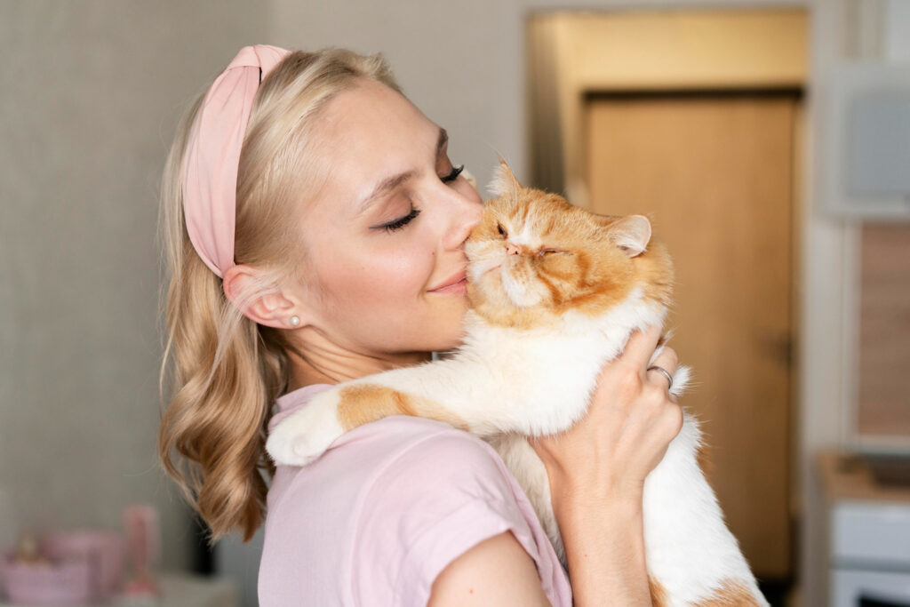 maitresse porte son chat et lui fait un calin
